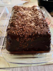 Homemade Gansito cake with smooth butter icing and coconut coating on white serving plate